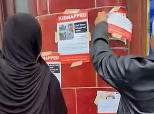 نساء يمزقن ملصقات الأطفال المختطفين لدى حماس ويهتفن: 